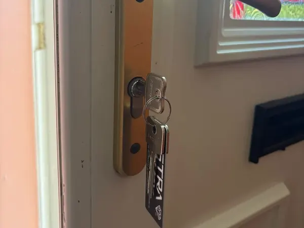 Euro cylinder with new keys under a gold lever handle on a composite door